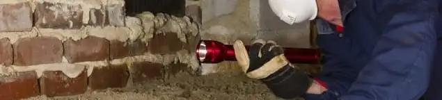 Pest control technician inspecting a crawl space for ant activity and entry points in Tulsa, OK