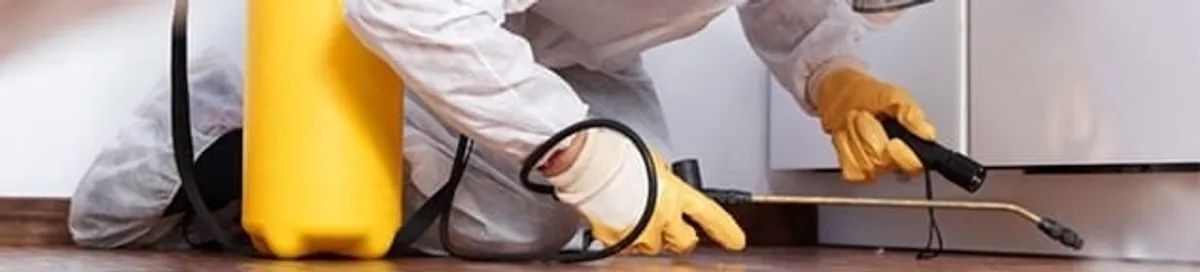 Roach exterminator treating cracks and crevices along kitchen baseboards in Tulsa, OK