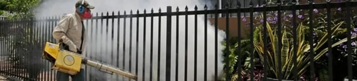 Mosquito control technician fogging a yard perimeter for mosquito reduction in Tulsa, OK